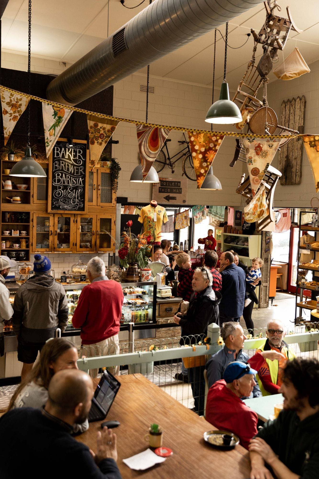 The busy café counter at the Uraidla Republic, with bunting and hanging lamps